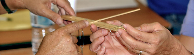 photo of teachers conducting an experiment with rulers, paper clips and chopsticks